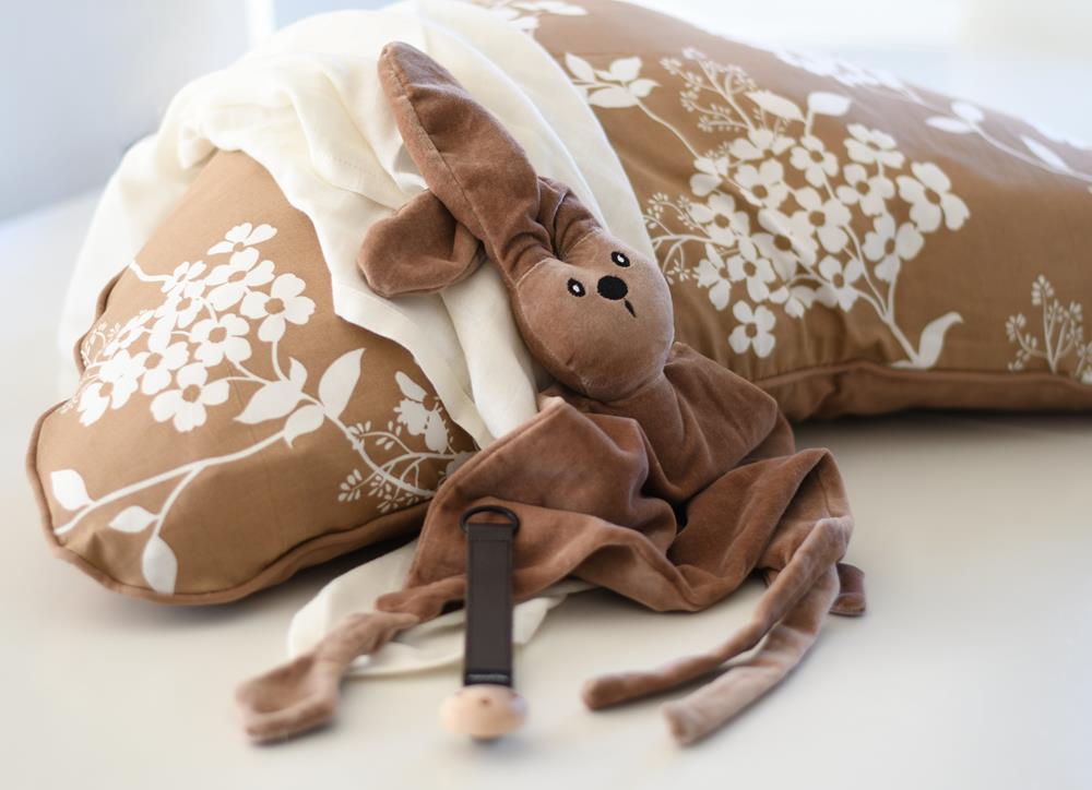 Ammepude med vildeblomster sammen med brun kaninbamse